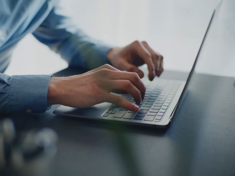 Momak u plavoj košulji koristi laptop